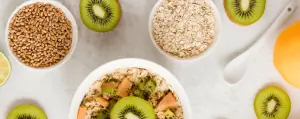 Foto van Vezels in bakjes vezelrijke producten, tafel gezellig gedekt met kiwi's en andere vezelrijke ontbijt mogelijkheden